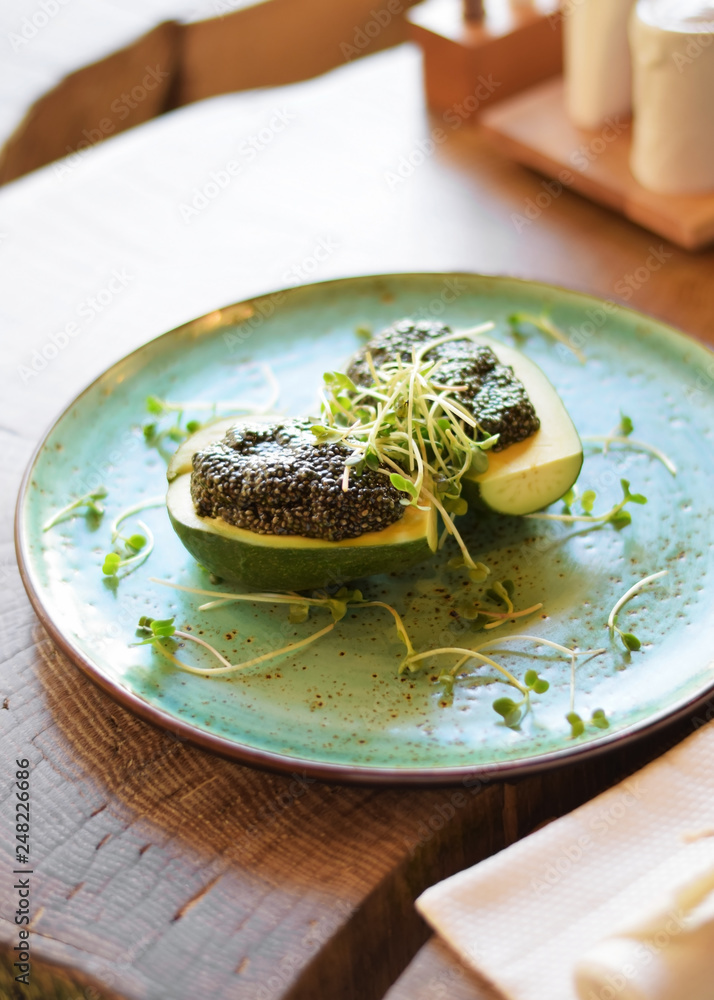 Avocado with Chia seeds on a large flat plate. The concept of healthy eating, vegetarianism, veganism and diet food Avocado with Chia seeds on a large flat plate. The concept of healthy eating, vegetarianism, veganism and diet food