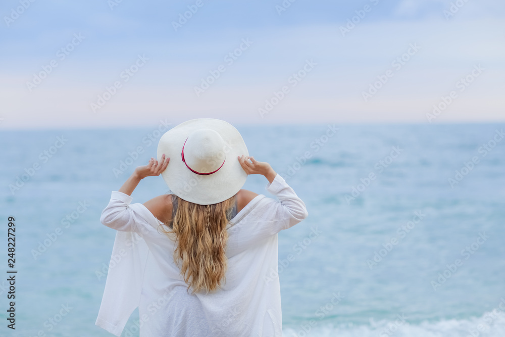 girl wearing a sea cap standing on the beach, clear sky, beautiful sea for relax.