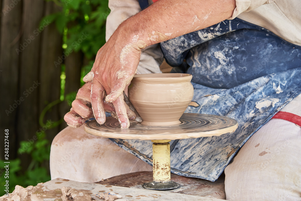 Potter forms a vase of clay on a potter's wheel