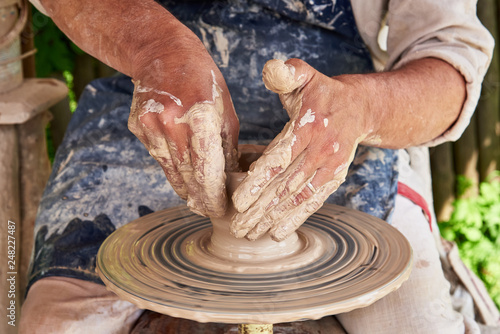 Potter forms a vase of clay on a potter's wheel