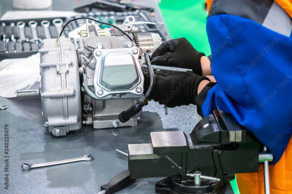 Engine repair. motor service. Mechanic disassembles the motor. Workbench with a vice. Man at work. Locksmith in the workshop. Engine repair. motor service. Mechanic disassembles the motor. Workbench with a vice. Man at work. Locksmith in the workshop.