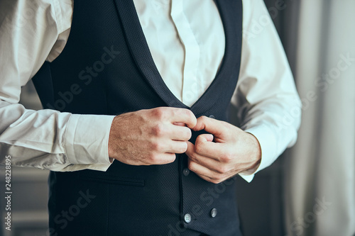 Businessman wears a jacket male hands closeup groom getting ready in the morning before wedding ceremony. Men Fashion