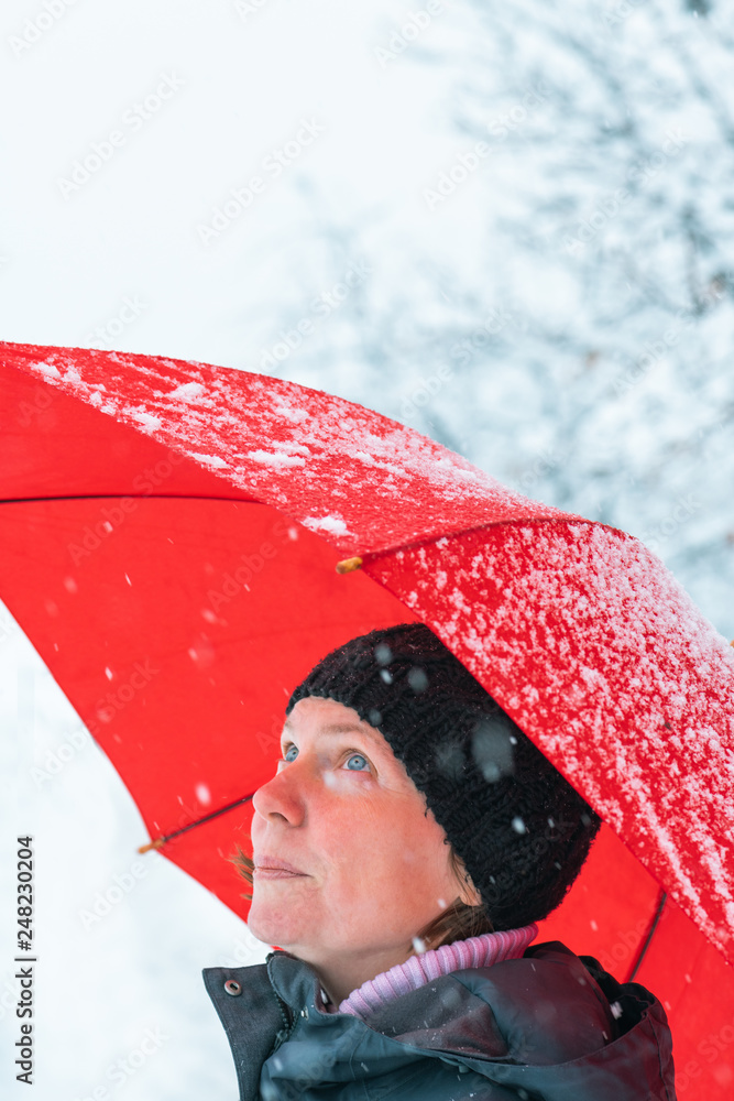 Φωτογραφία Portrait of beautiful adult female with umbrella in snow