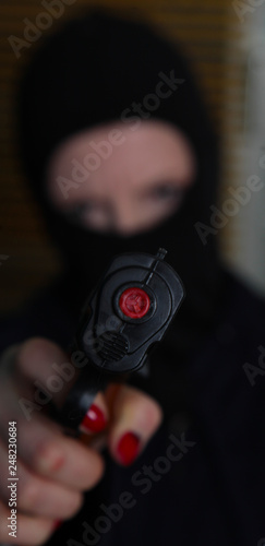 Verbrecher mit Maske und Pistole photo