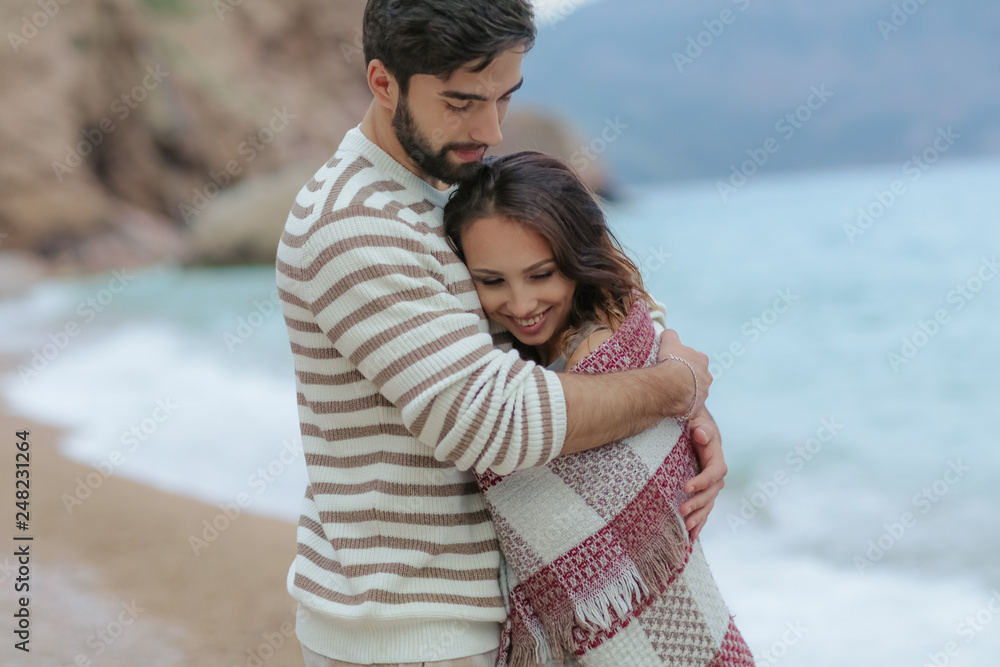 Young couple in love on the beach.Beautiful couple in white. Lovers holding hands and hugging