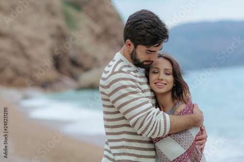 Young couple in love on the beach.Beautiful couple in white. Lovers holding hands and hugging