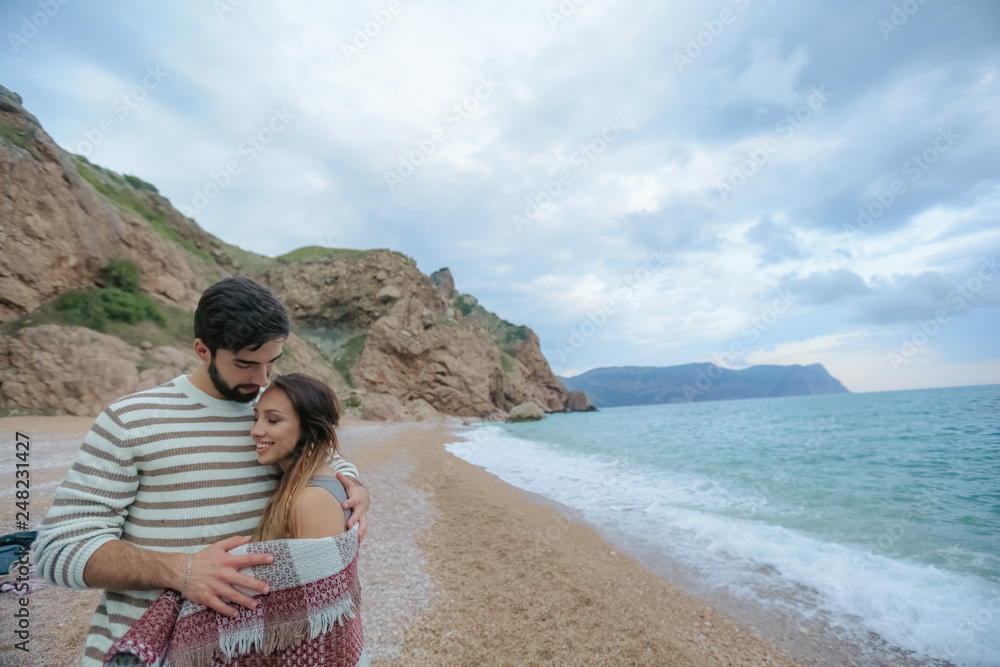 Young couple in love on the beach.Beautiful couple in white. Lovers holding hands and hugging