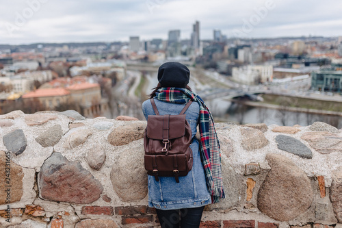 Stylish girl in jeans jacket walk at the Vilnius background on Gediminas Castle, Lithuania