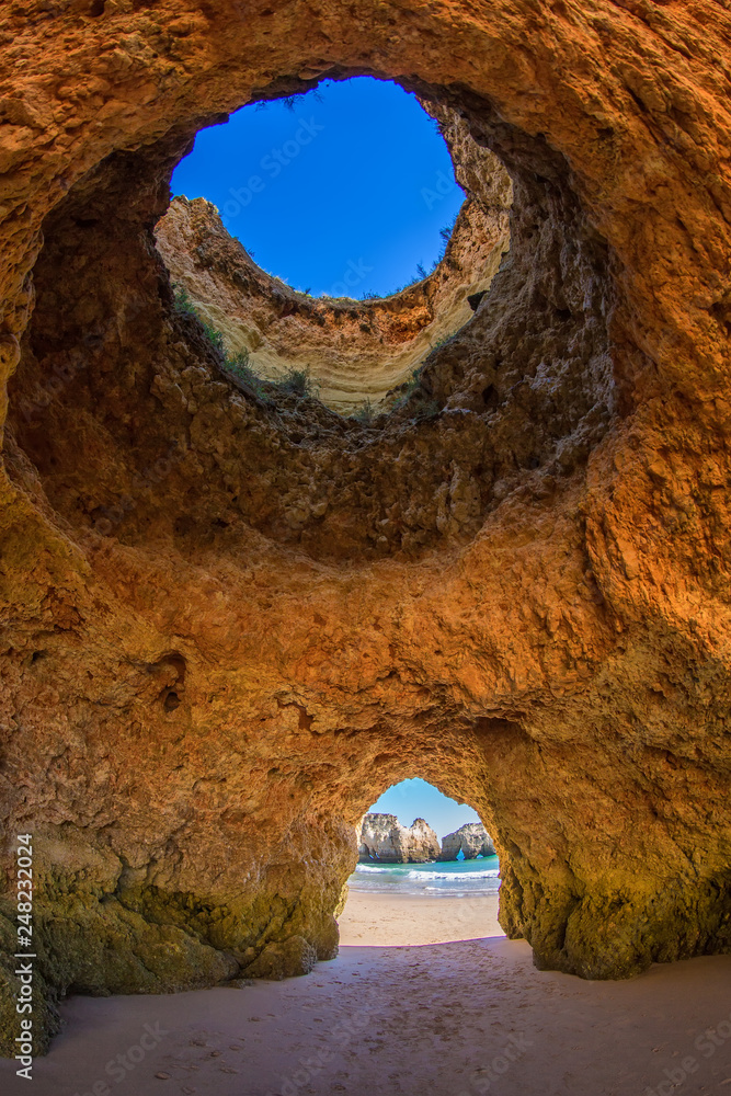 Famous caves in a beach rock formation in the Algarve, Portugal. Through  the one cave you