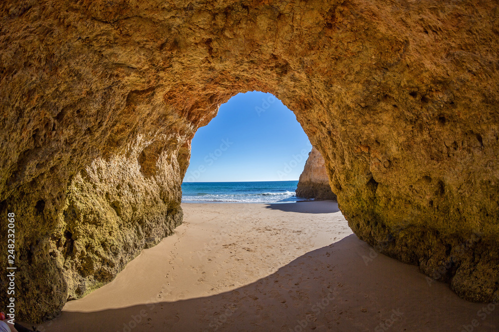 Famous caves in a beach rock formation in the Algarve, Portugal. Through the cave you can see the ocean.