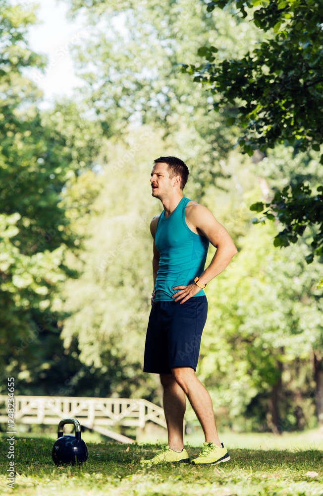 Fitness Trainer doing workout in nature with the kettle bell Fitness Trainer doing workout in nature with the kettle bell