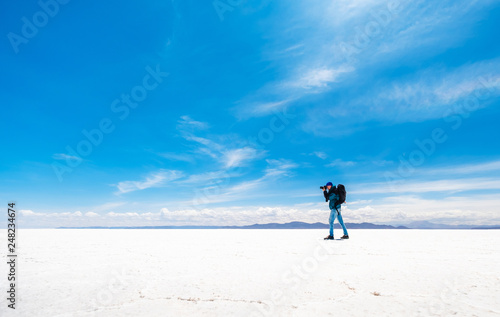 Tourist taking photo in sunshine Salar de Uyuni