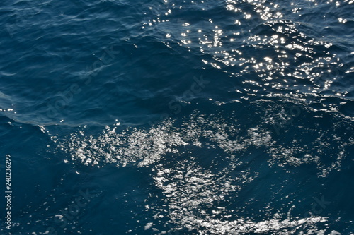 dark blue waves of a sea water in summer under the sun light
