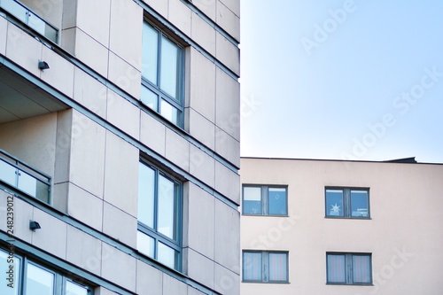 Modern apartment buildings on a sunny day with a blue sky. Facade of a modern apartment building © Grand Warszawski