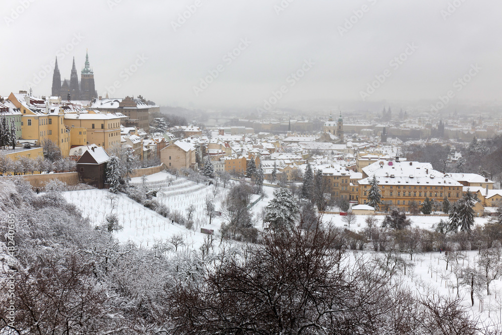 Snowy foggy Prague City with gothic Castle from Hill Petrin, Czech republic