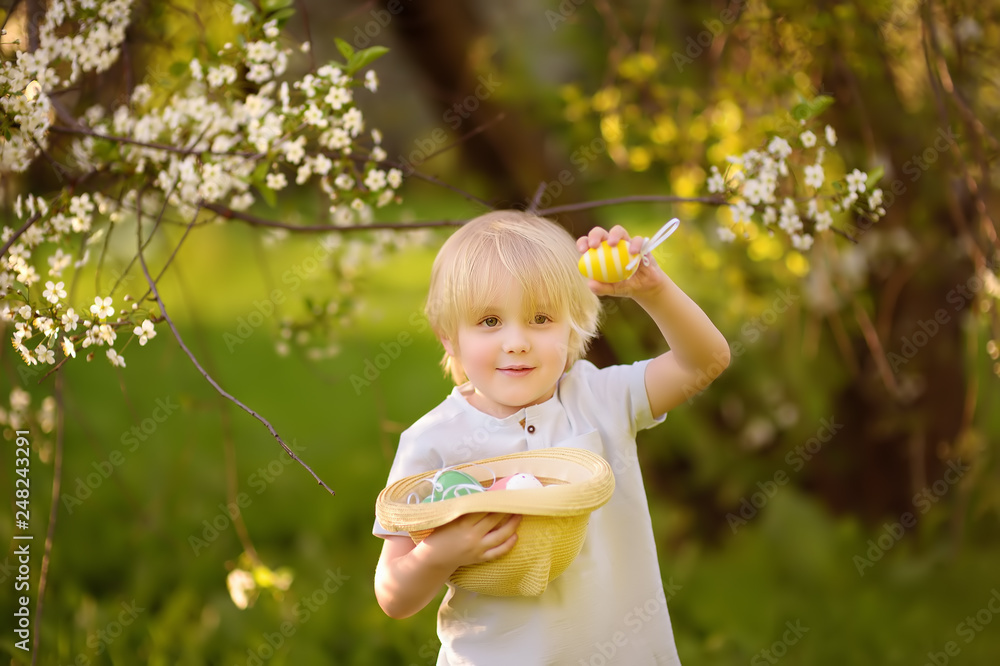 Cute little boy hunts for easter egg in spring park. Cute little boy hunts for easter egg in spring park.