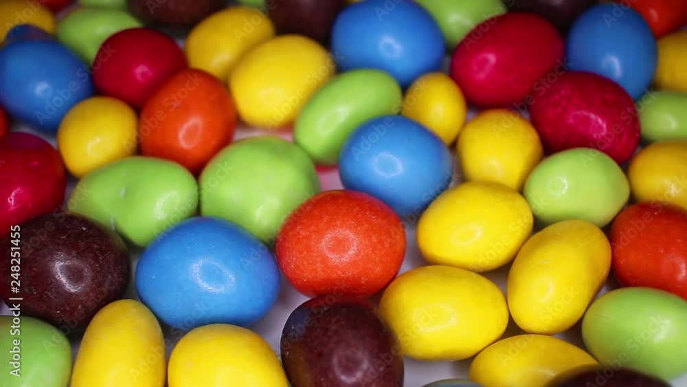 Colorful chocolate candy drops candies rainbow sweets food closeup texture pattern. Seamless looping video footage