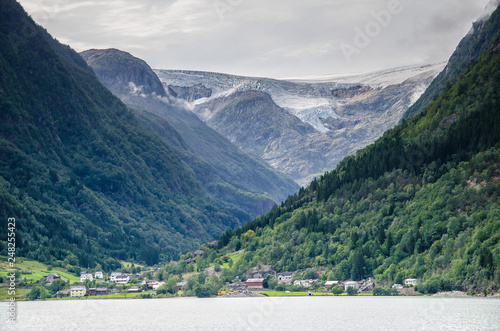 DIstant view of a Buarbreen glacier valley with a small village in front in Odda region, Norway photo