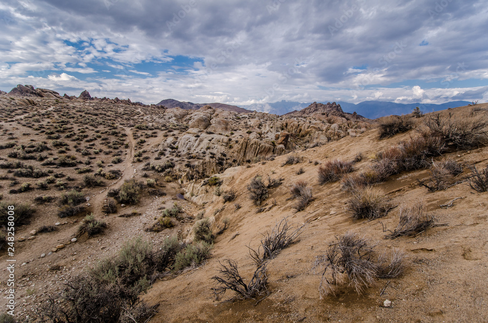 Trail through giant boulders to the Moibus Arch in Alabama Hills California, in the Eastern Sierra Nevada mountains. Many classic western movies were filmed in this area Trail through giant boulders to the Moibus Arch in Alabama Hills California, in the Eastern Sierra Nevada mountains. Many classic western movies were filmed in this area