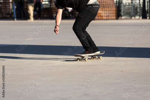 Person riding a skate board in an urban asphalt park