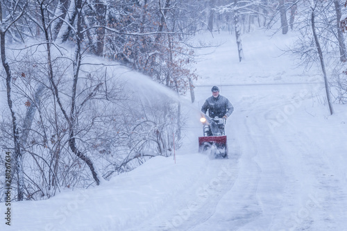 Принти на полотні An old white man is using snow blower to plow / blow snow