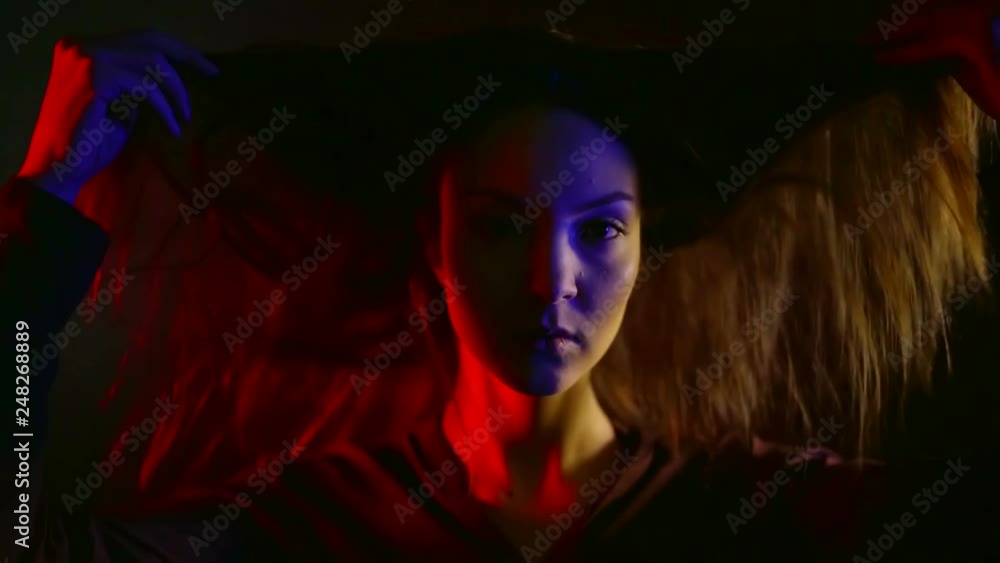 sexual young woman is playing with her hair in darkness, tempting a camera sexual young woman is playing with her hair in darkness, tempting a camera