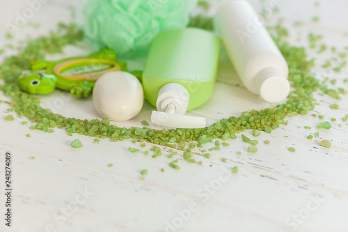 Shampoo bottles on wooden backround. Baby bath accessories. Child toilet stuff. Bathroom tubes  balm  sea salt  soap.