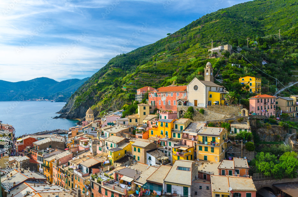 Aerial view of Vernazza village with typical colorful multicolored buildings houses, harbor, marina, green hills and Genoa Gulf, Ligurian Sea, National park Cinque Terre, La Spezia, Liguria, Italy