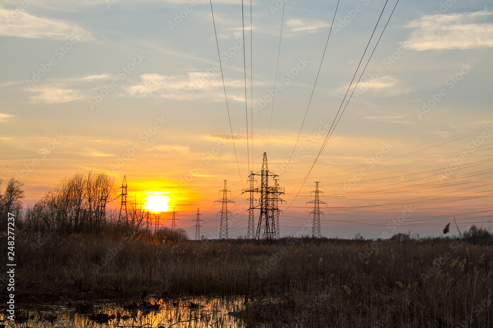 High voltage power tower and power lines at sunset