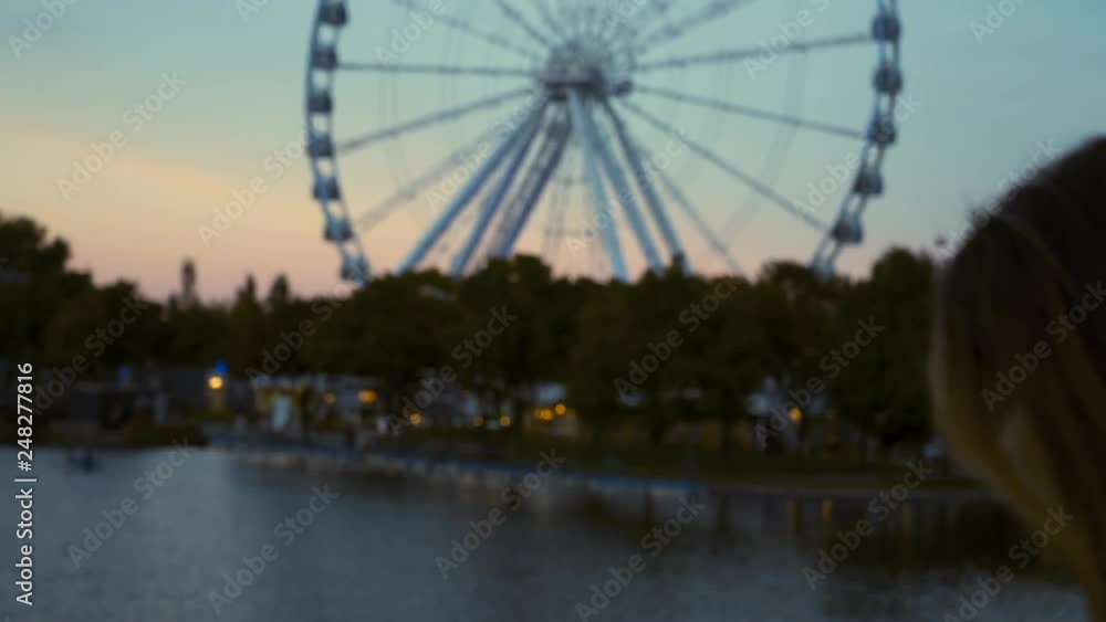 Slow Motion Focus Transition: Back of Woman's Head to Montreal Observation Wheel Slow Motion Focus Transition: Back of Woman's Head to Montreal Observation Wheel