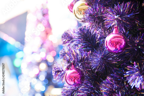 Purple colour christmas tree with little pink and golden ball hang on christmas tree selective focus