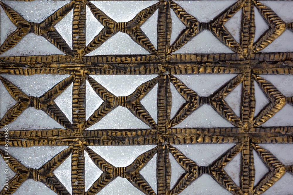 Old Carved wooden latticework with flowers and squares design creating a perforated wall
