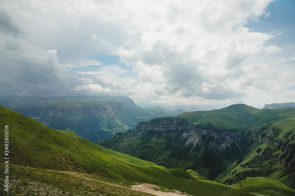 Fototapeta premium Dramatic landscape of a green valley at the foot of the Inal Plateau in the North Caucasus