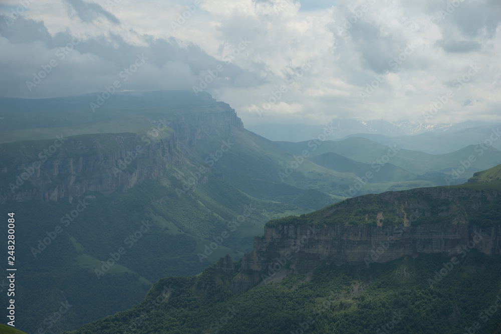 Fototapeta premium Dramatic landscape of a green valley at the foot of the Inal Plateau in the North Caucasus