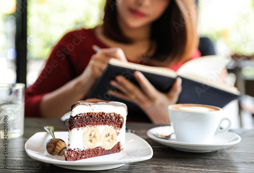 Red shirt woman  enjoy relax time and writing notebook with cup of coffee and chocolate banana cake Choco banana cake Coffee time Selective focus