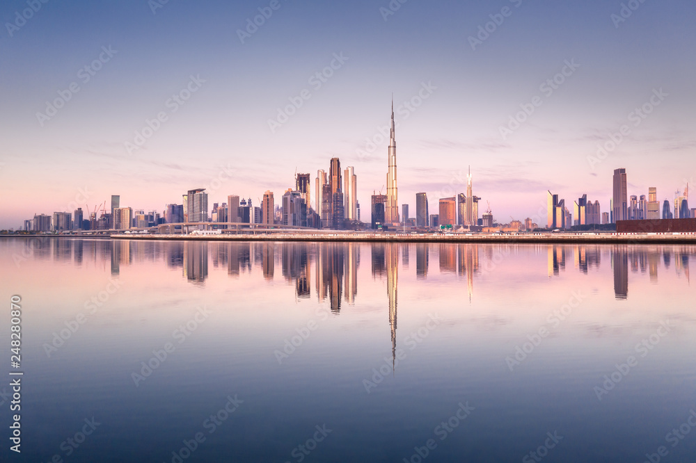Beautiful colorful sunrise lighting up the skyline and the reflection of Dubai Downtown. Dubai, United Arab Emirates. - obrazy, fototapety, plakaty 