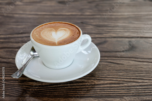 Cappuccino coffee in white cup lay on wooden table,Relax time with coffee,Art of coffee