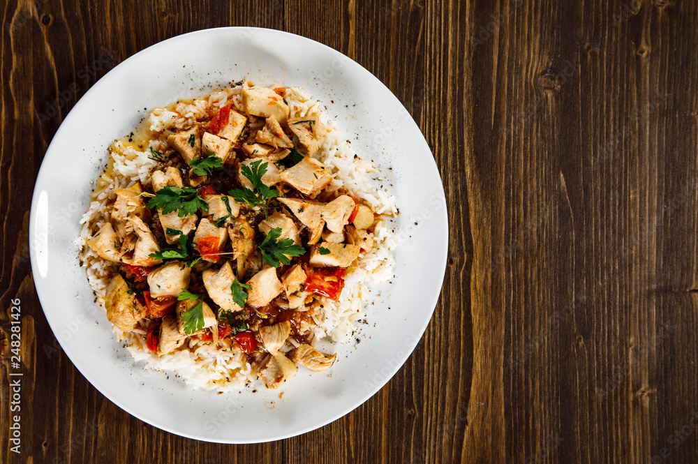 Grilled meat, white rice and vegetables on wooden table Grilled meat, white rice and vegetables on wooden table