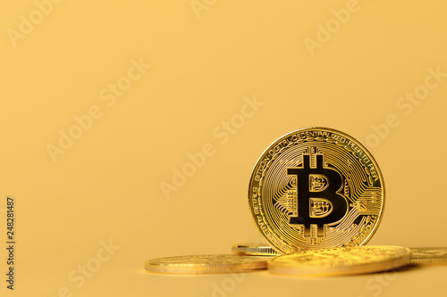 Gold bitcoin cryptocurrency coins on yellow backgound photo