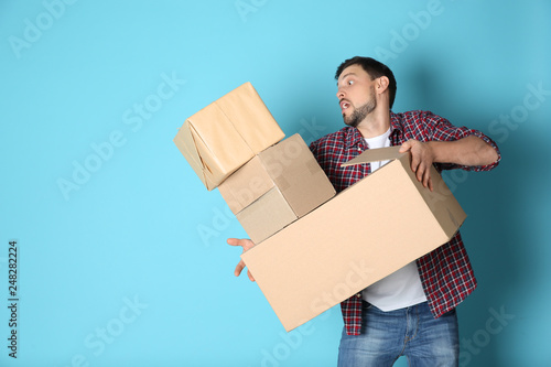 Fényképezés Man dropping moving boxes on color background. Space for text