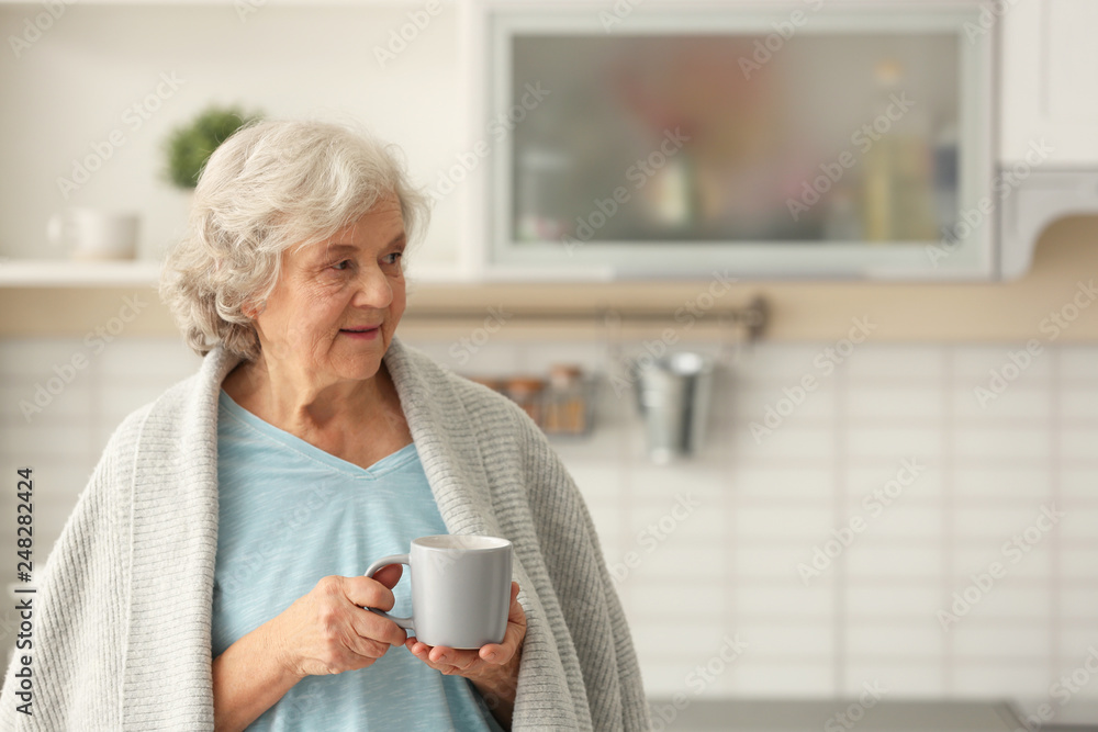 Elderly woman with cup of tea in kitchen. Space for text Elderly woman with cup of tea in kitchen. Space for text