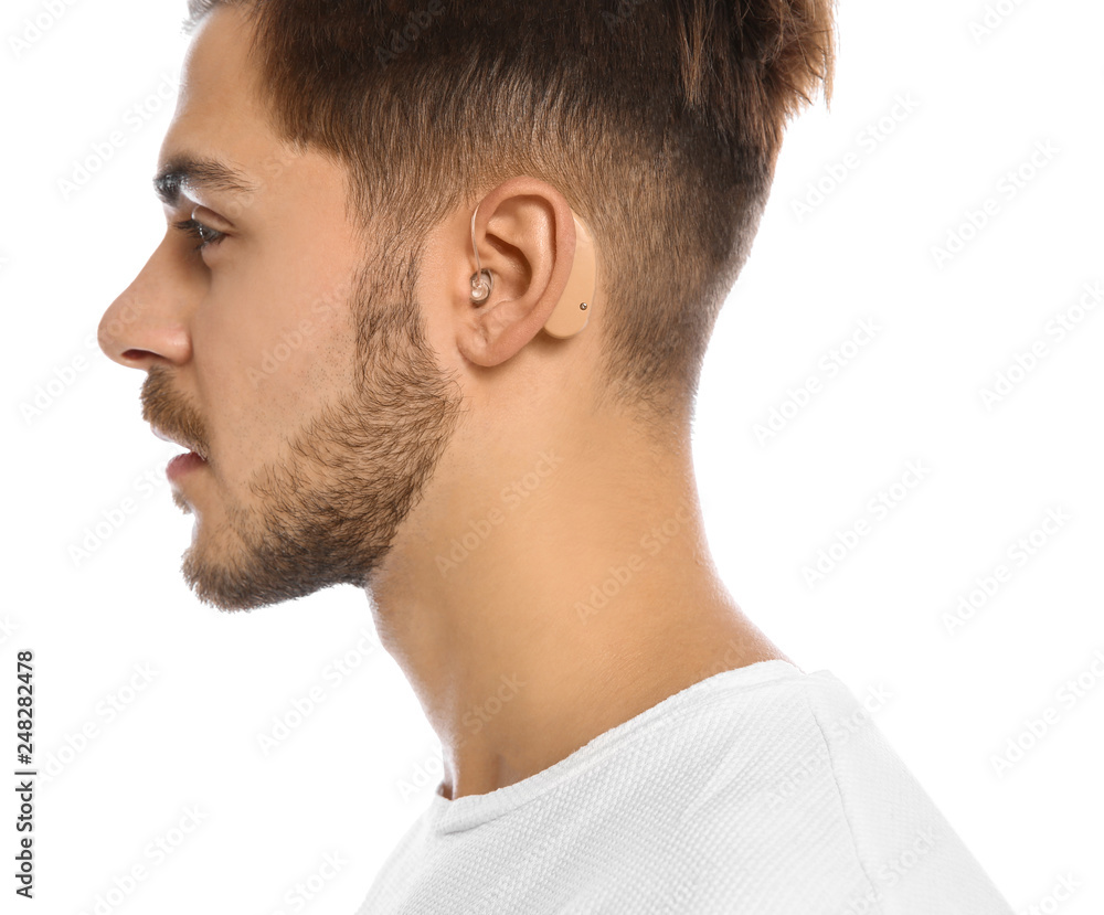 Fototapeta premium Young man with hearing aid on white background