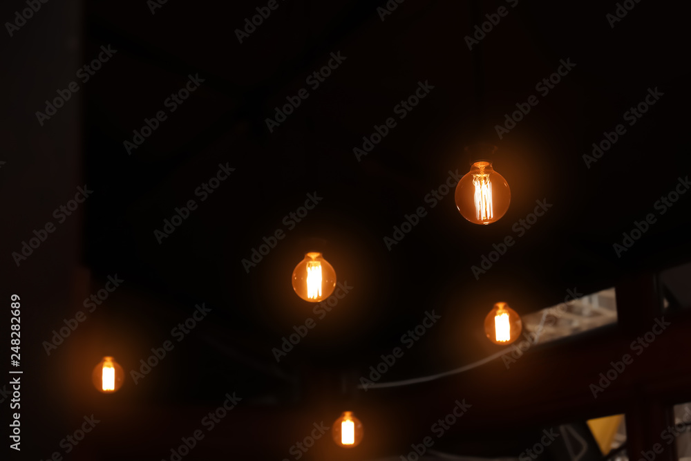 Glowing lamp bulbs in dark room. Space for text Glowing lamp bulbs in dark room. Space for text