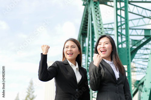 Two Business womens happy with jobs success,Two Asian women business team smiling and looking forward confidently