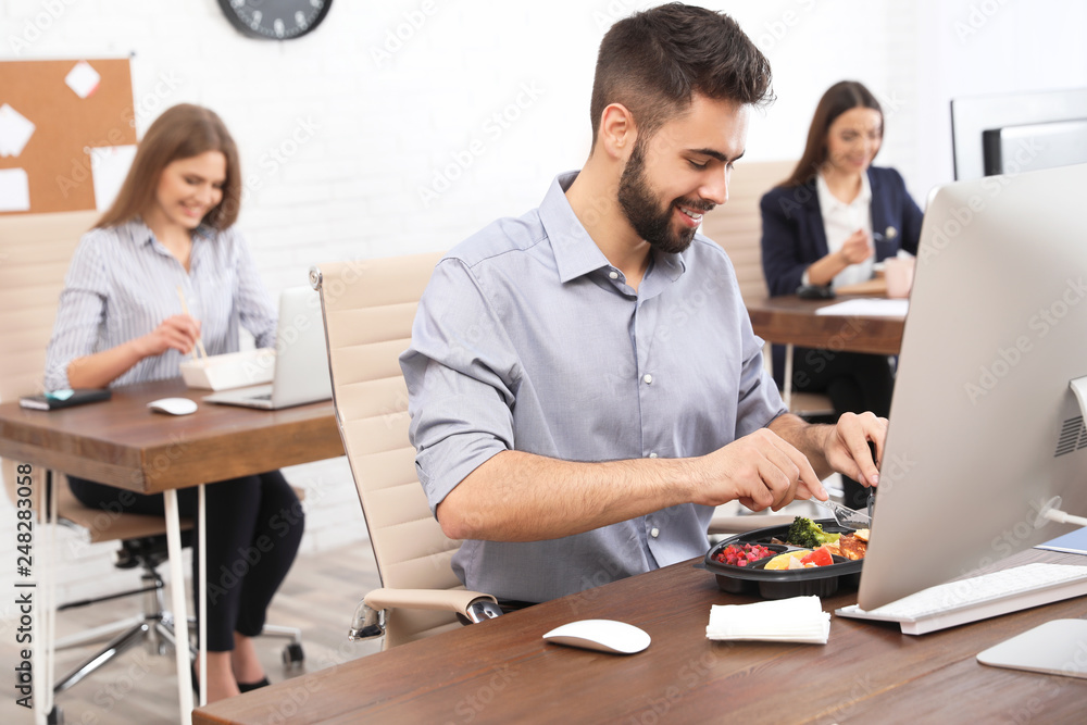 Office employees having lunch at workplace. Food delivery Office employees having lunch at workplace. Food delivery