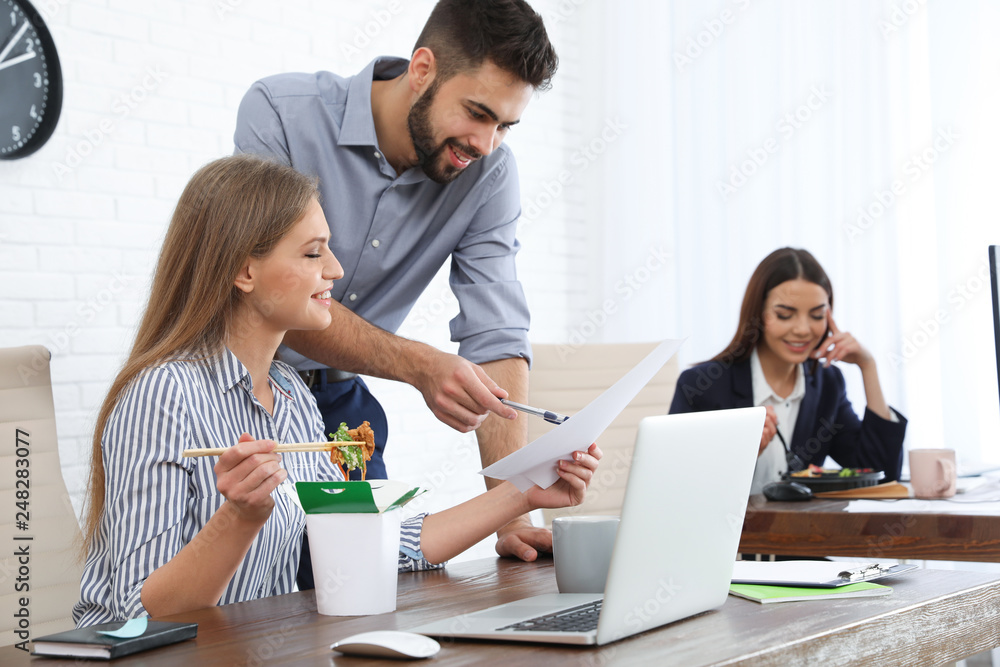 Office employees having lunch at workplace. Food delivery Office employees having lunch at workplace. Food delivery