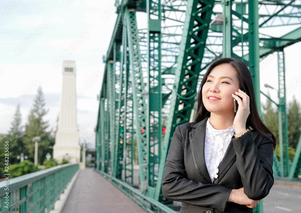 Asian business women using a smartphone to talk for job,Asian smile with talking to some people by smartphone Asian business women using a smartphone to talk for job,Asian smile with talking to some people by smartphone