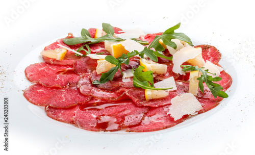 Veal carpaccio with arugula on white background