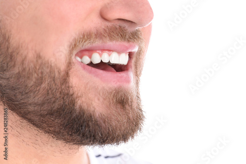 Young man with healthy teeth smiling on white background, closeup