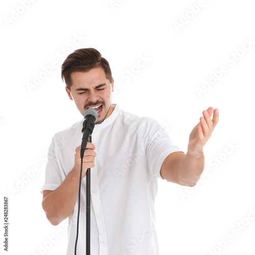 Young handsome man singing in microphone on white background